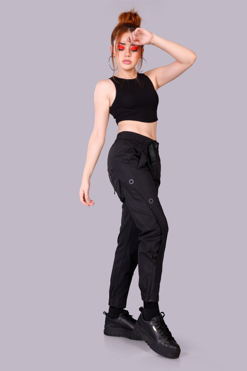 METTLE TWEED black polyester-spandex tactical cargo pants with adjustable waist and matte black rivets.