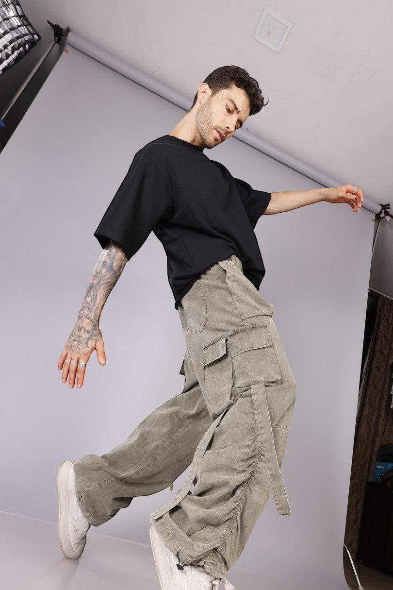 METTLE TWEED Peepal wide-leg cargo pants in washed khaki with oversized flap pockets and dangling straps.