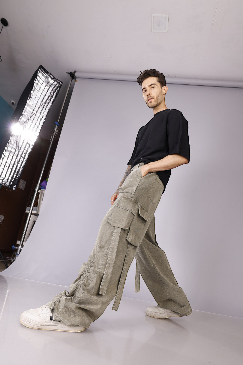 METTLE TWEED Peepal wide-leg cargo pants in washed khaki with oversized flap pockets and dangling straps.