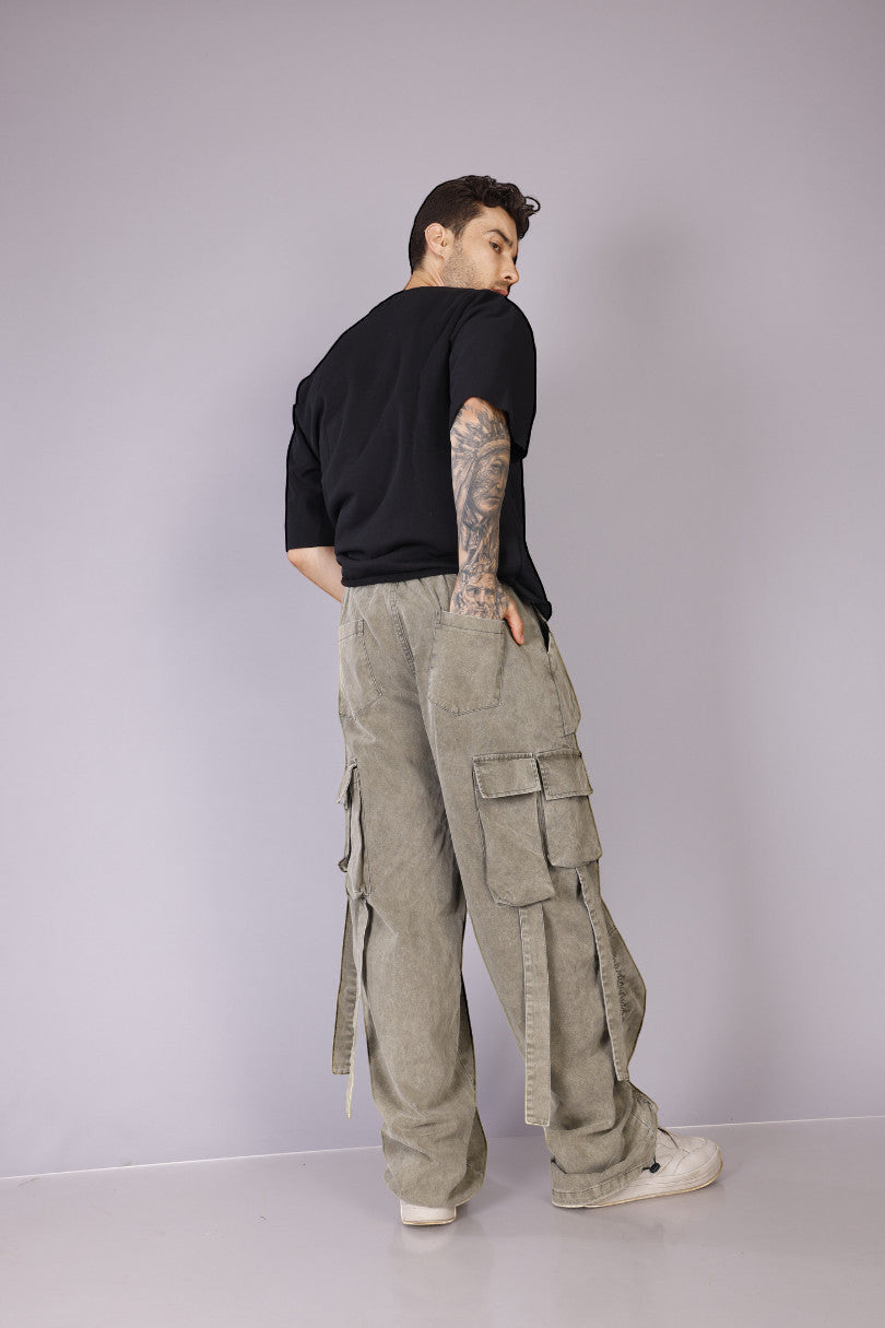 METTLE TWEED Peepal wide-leg cargo pants in washed khaki with oversized flap pockets and dangling straps.