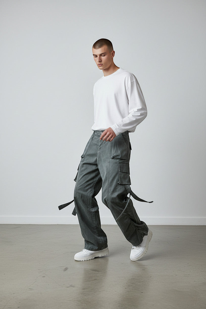 METTLE TWEED Peepal grey wide-leg cargo pants with oversized flap pockets and dangling straps.